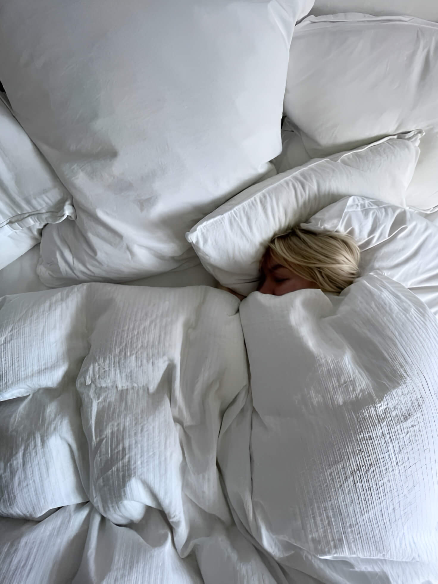 Egy lány nagyon be van búrkolózva az ágyába és mélyen alszik