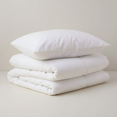 Összehajtott paplan tetejére téve egy nagy párna